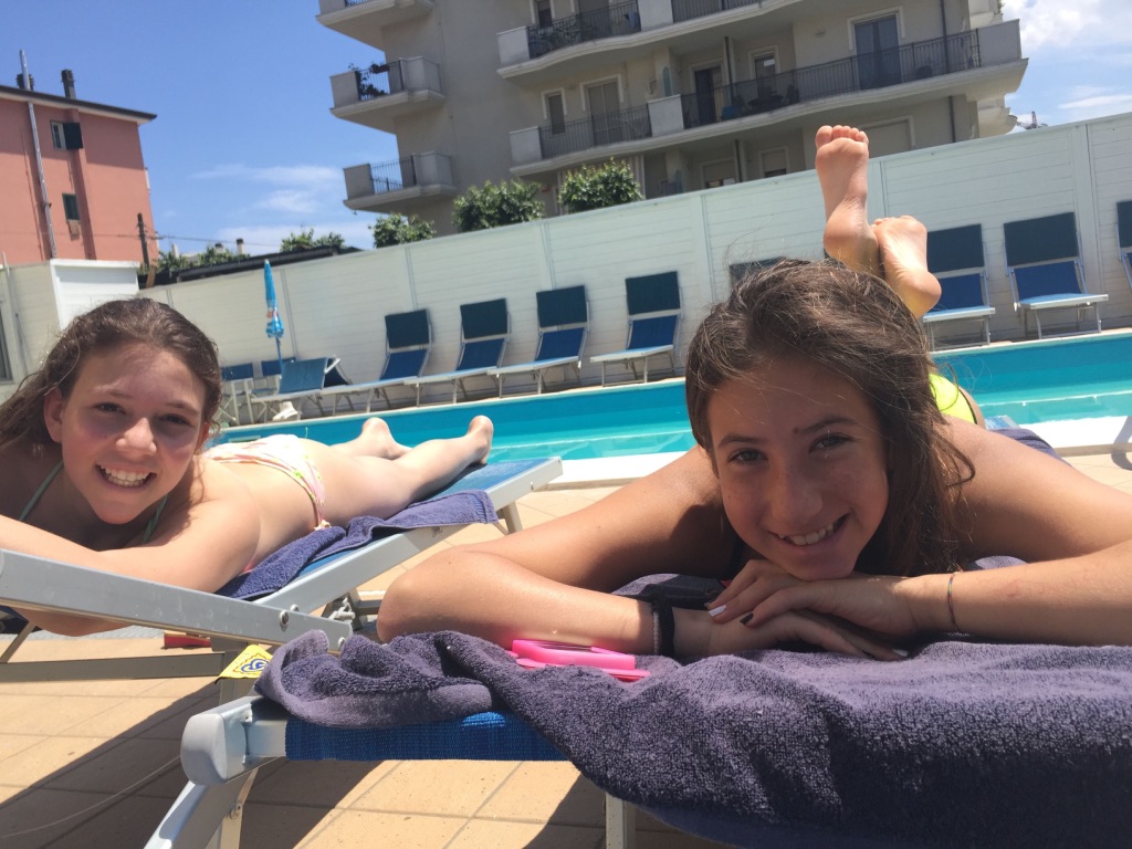 ragazzine sorridono prendendo il sole su lettini piscina hotel viking