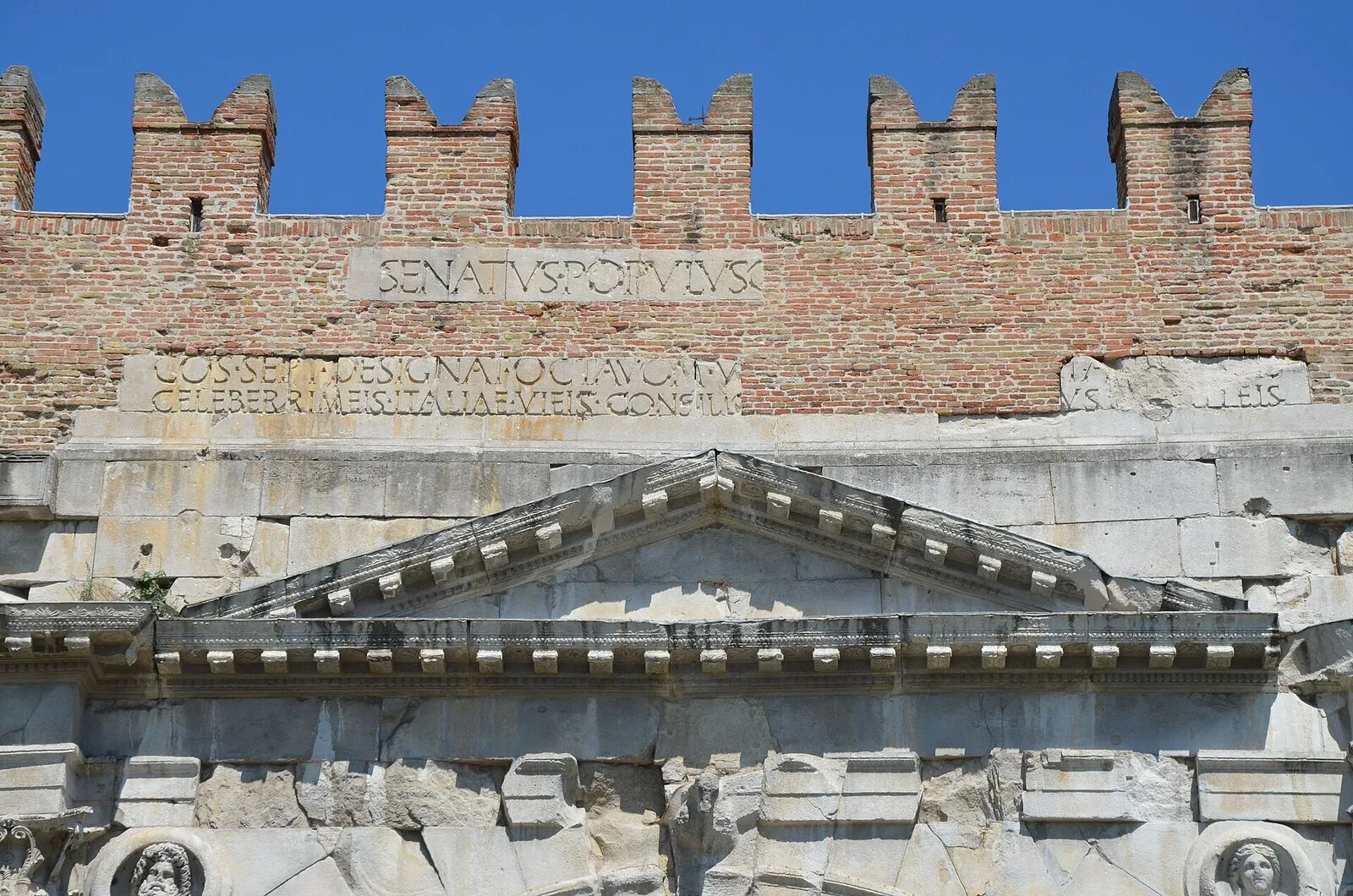 Particolare dell'attico dell'Arco d'Augusto con l'iscrizione dedicatoria, il timpano e i clipei