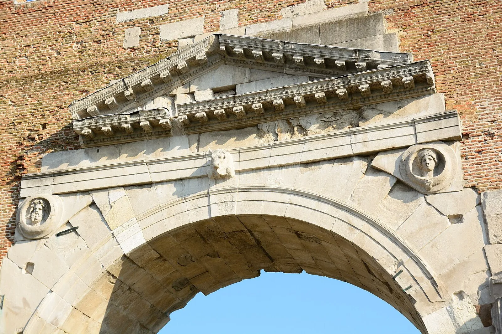 Dettaglio del timpano e di un clipeo con divinità sull'Arco d'Augusto