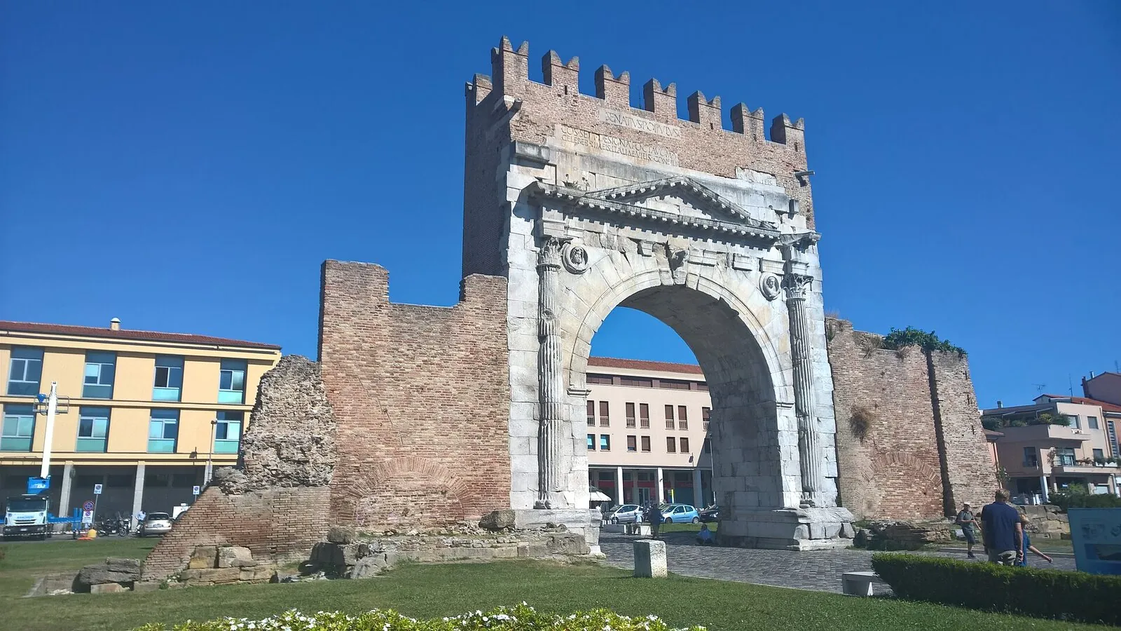 L'Arco d'Augusto con la merlatura medievale e i resti delle mura romane ai lati