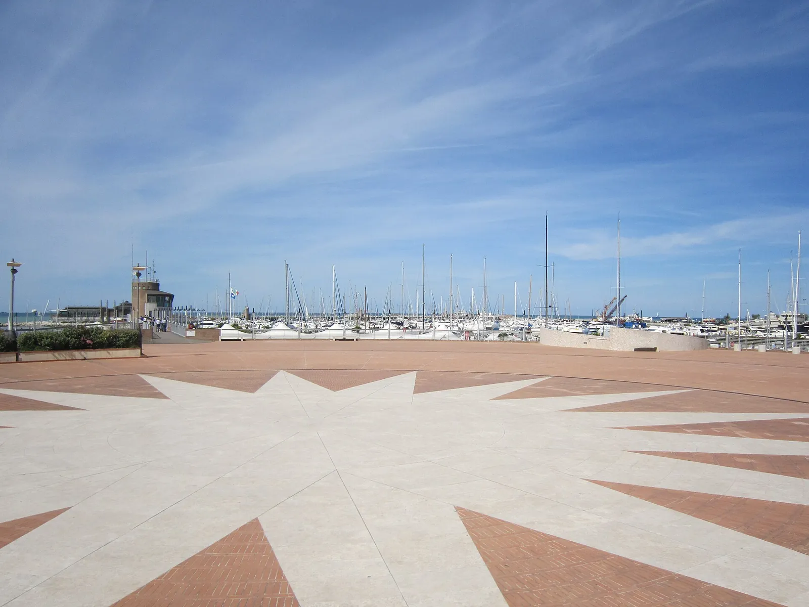 La piazza con la rosa dei venti e le barche ormeggiate nella darsena Marina di Rimini
