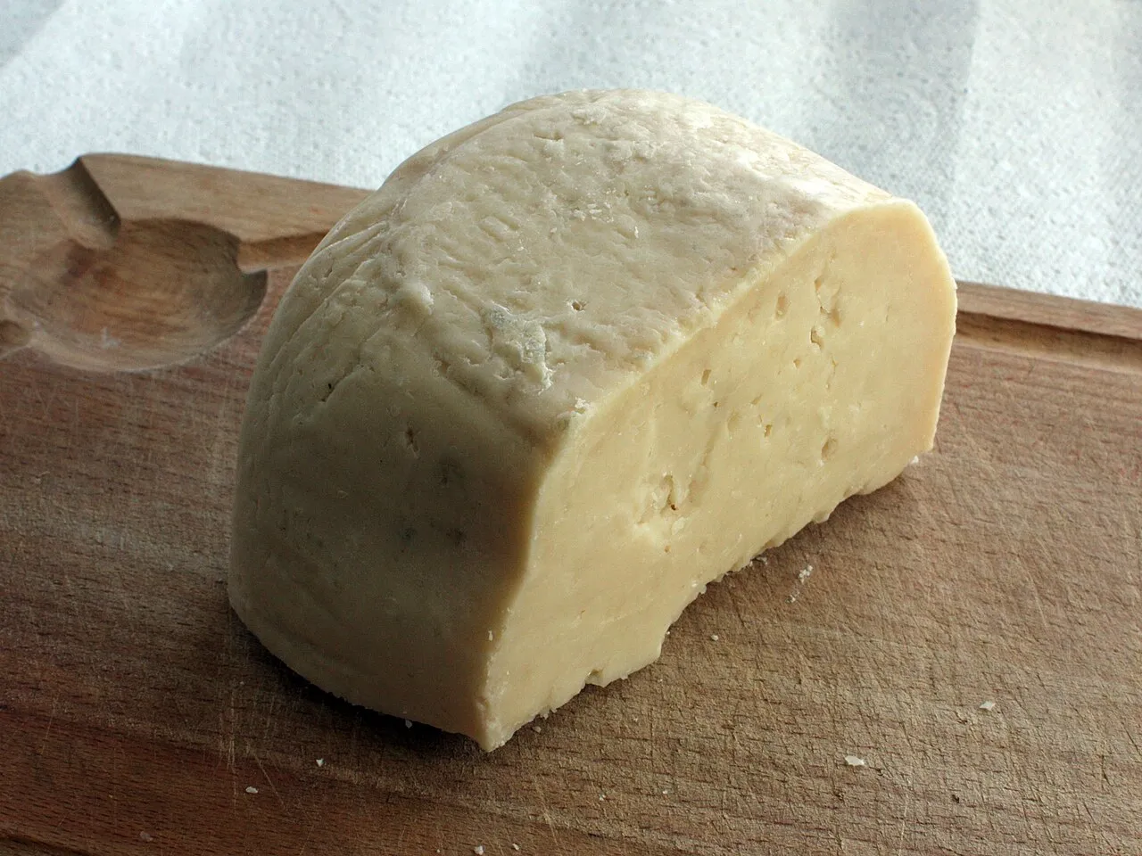 Une meule de formaggio di fossa coupée sur une planche en bois