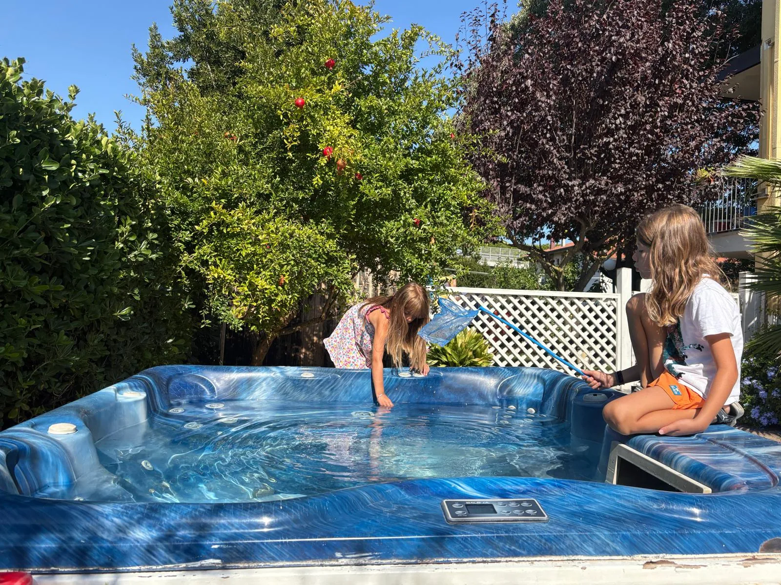 Maxi Jacuzzi Hotelu Viking w ogrodzie, między granatowcem a żywopłotem, z krystalicznie czystą wodą