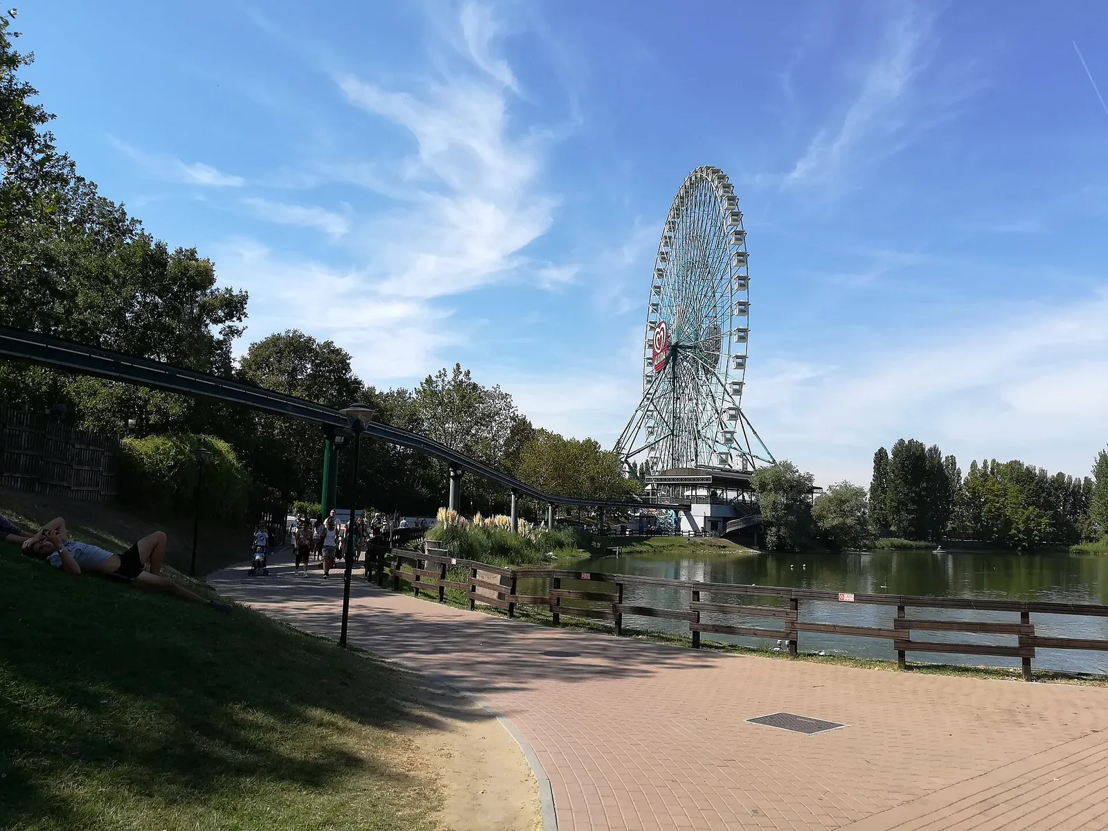 La ruota panoramica Eurowheel affacciata sul lago, vista dal vialetto lungo l'acqua.