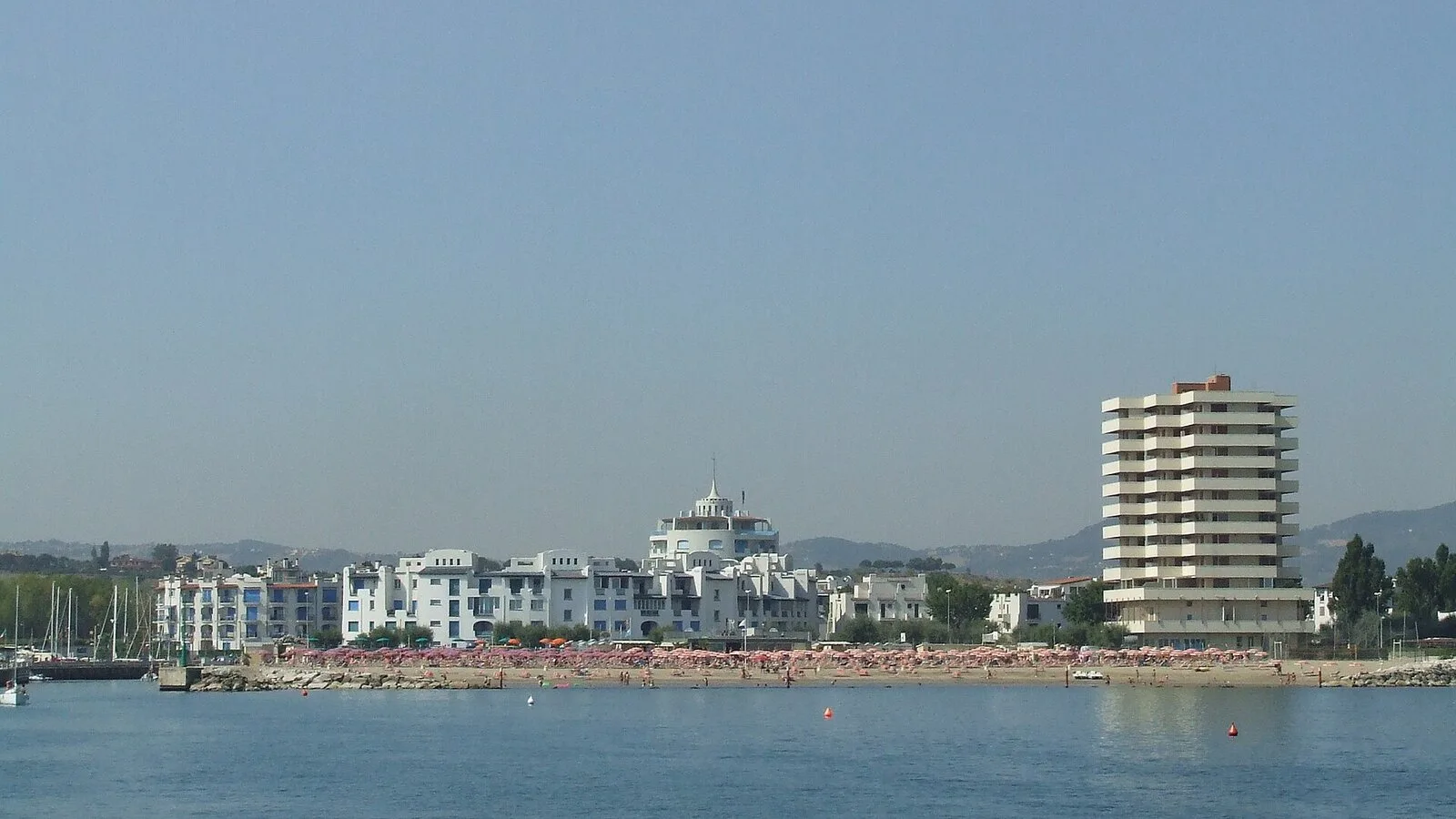 Portoverde vista dal mare, con la spiaggia, le palazzine bianche e le barche della darsena