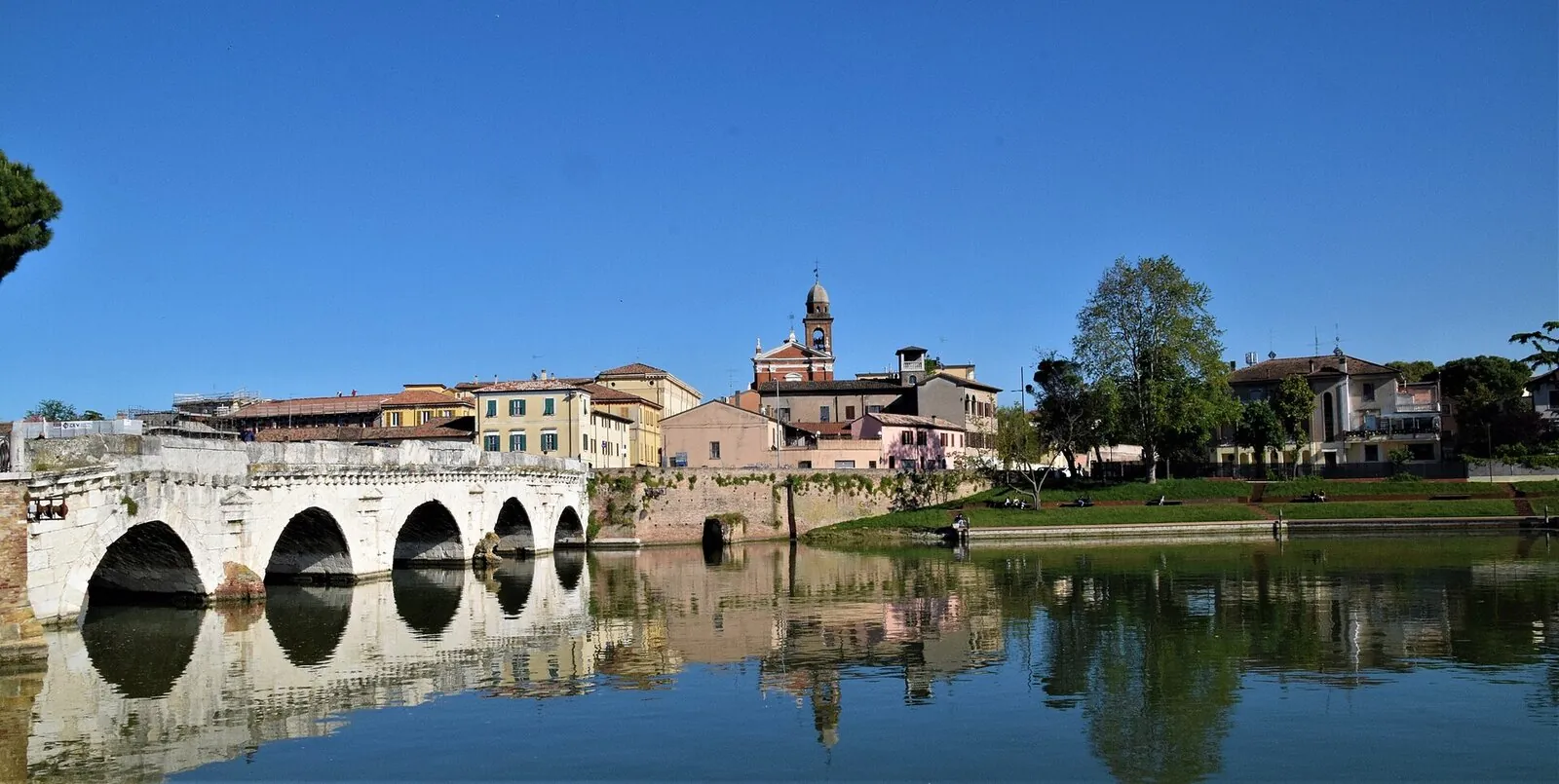 Il Ponte di Tiberio con le cinque arcate riflesse nell'invaso, visto dal Borgo San Giuliano