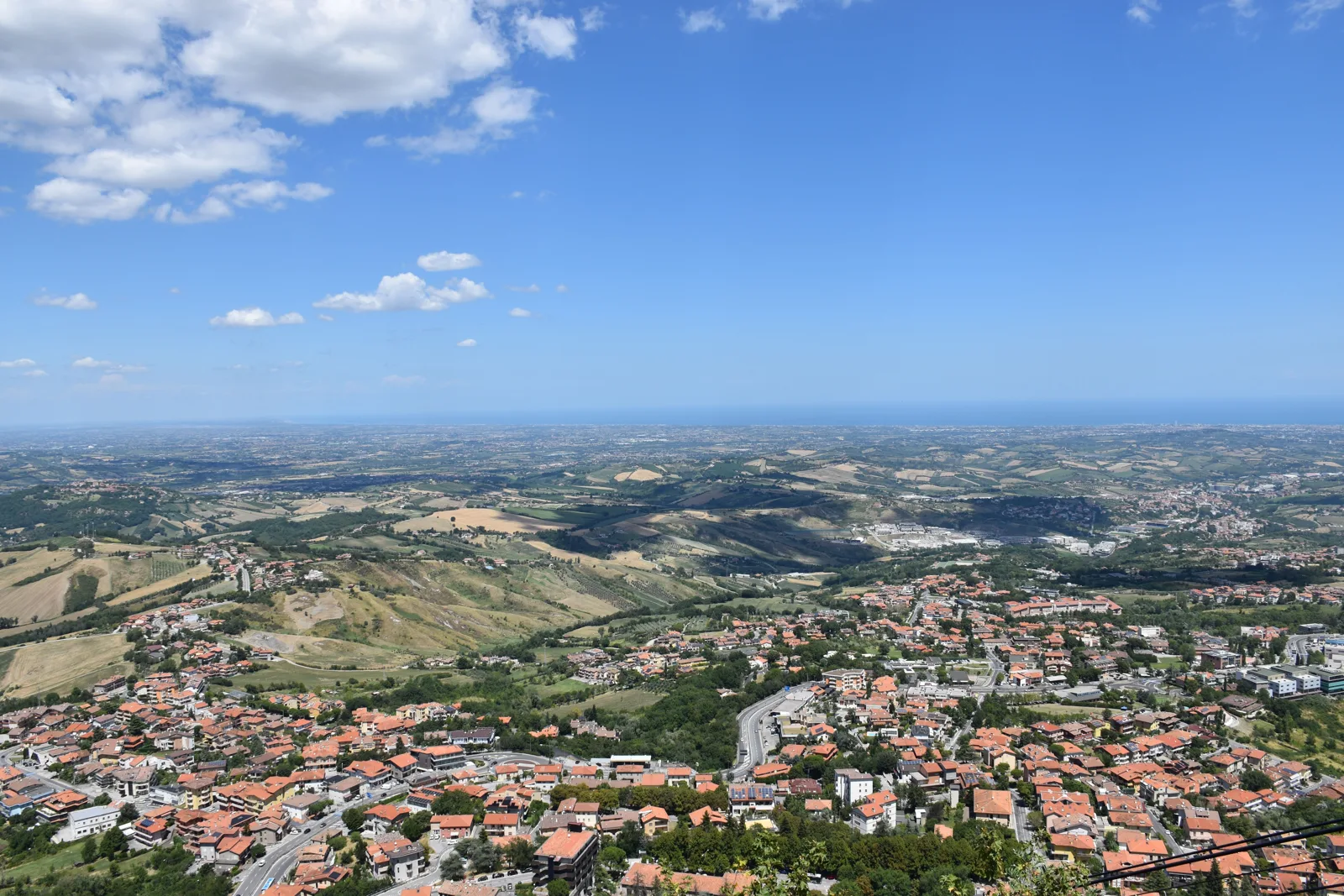 Der Ausblick vom Monte Titano in San Marino über die Hügel und das Tal bis zum Meer der Riviera