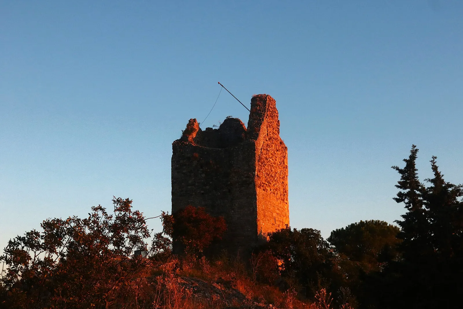 La torre di Torriana illuminata dal sole al tramonto.