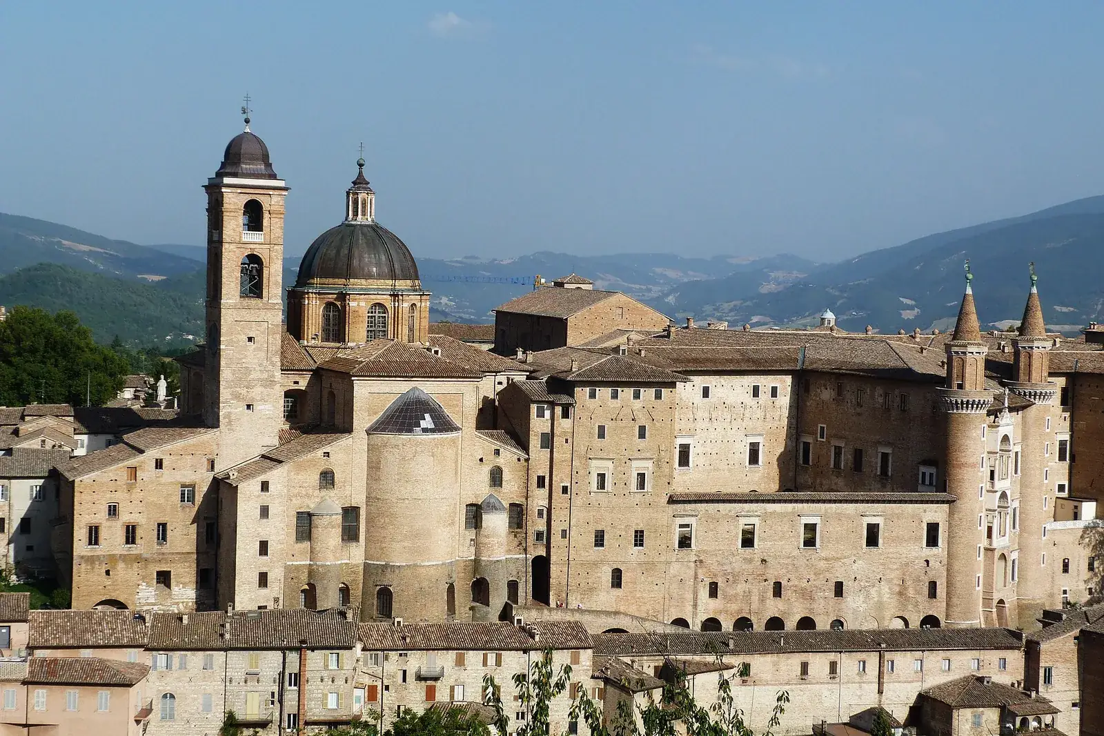 Blick auf Urbino mit Glockenturm, Domkuppel und Palazzo Ducale, im Hintergrund Hügel