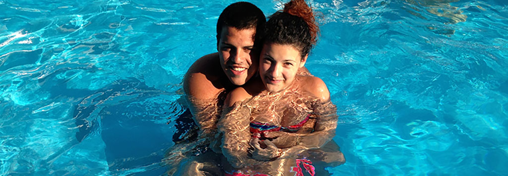 ragazzi piscina abbracciati sorridenti