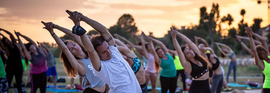 Lezione di yoga all'alba sulla spiaggia di Rimini con decine di partecipanti