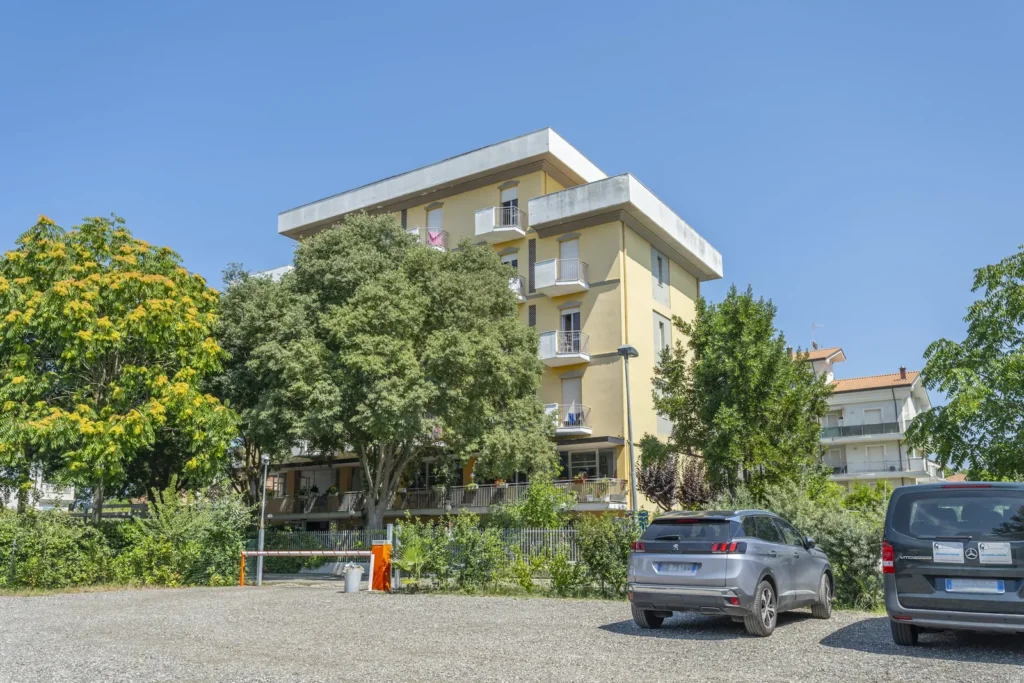 Facciata dell'Hotel Viking tra gli alberi vista dal parcheggio privato