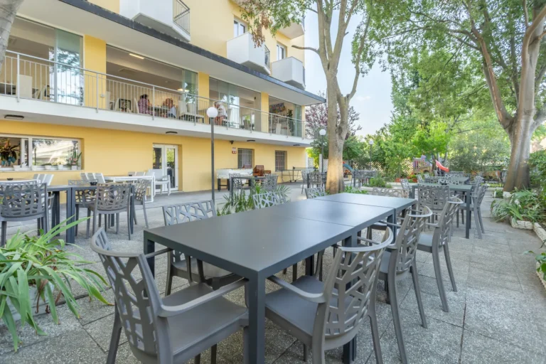Terrazza con tavoli all'aperto all'ombra degli alberi, Hotel Viking Viserbella