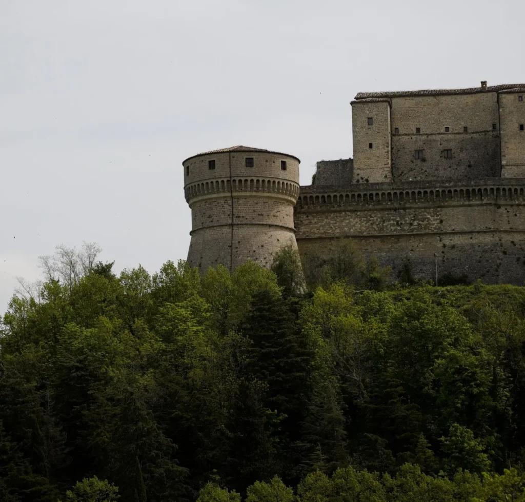 La fortezza di San Leo con il torrione circolare che domina il bosco