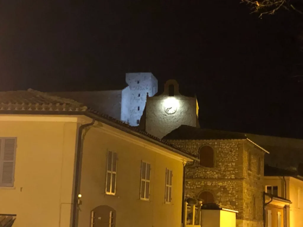 La Rocca di Verucchio illuminata di notte sopra i tetti del borgo