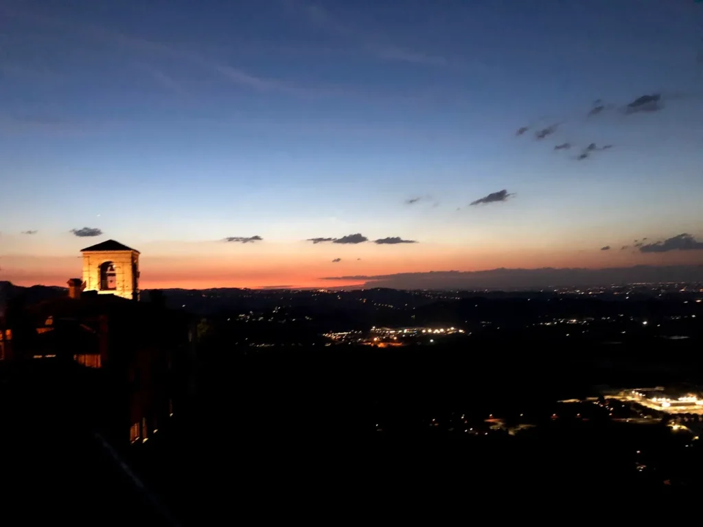 Tramonto da Verucchio con il campanile illuminato e la Valmarecchia fino alla costa
